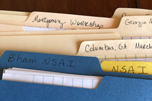 Picture of file folders containing information about songwriting workshops.