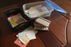 photo pieces of paper and storage box with notebooks.